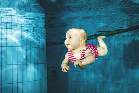 Baby swimming under water in pool