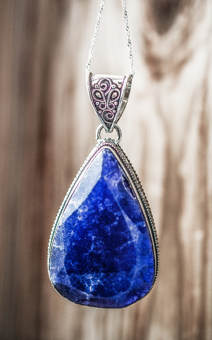 silver-colored necklace with blue gemstone