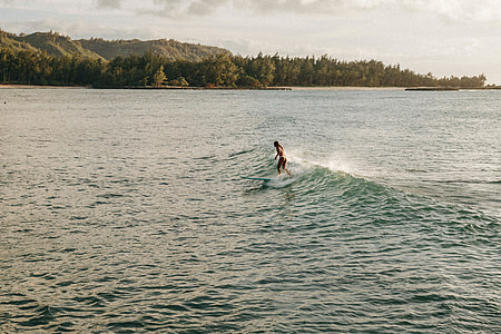 woman in bikini surfing on ocean wave
