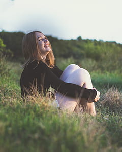 woman smiling white sitting on grass field