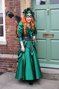 woman in green dress standing near door at daytime