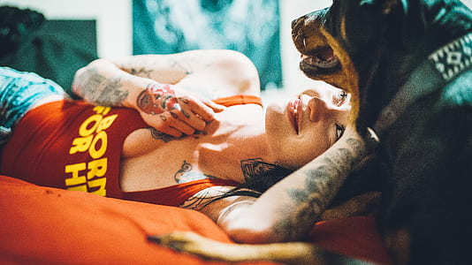 woman in red tank top with adult Rottweiler