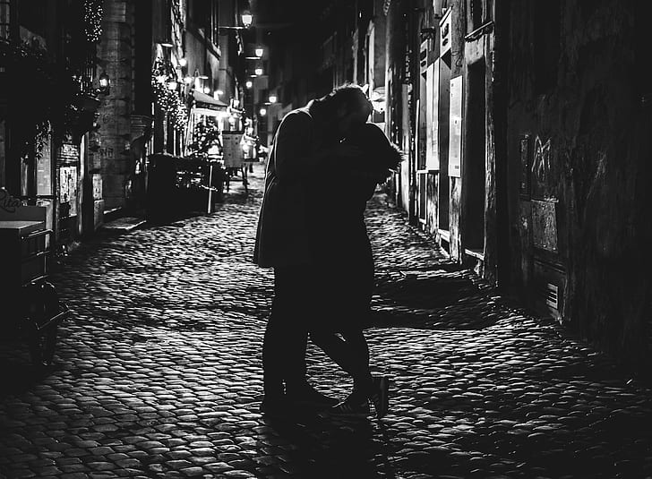 black and white photo of man and woman kissing