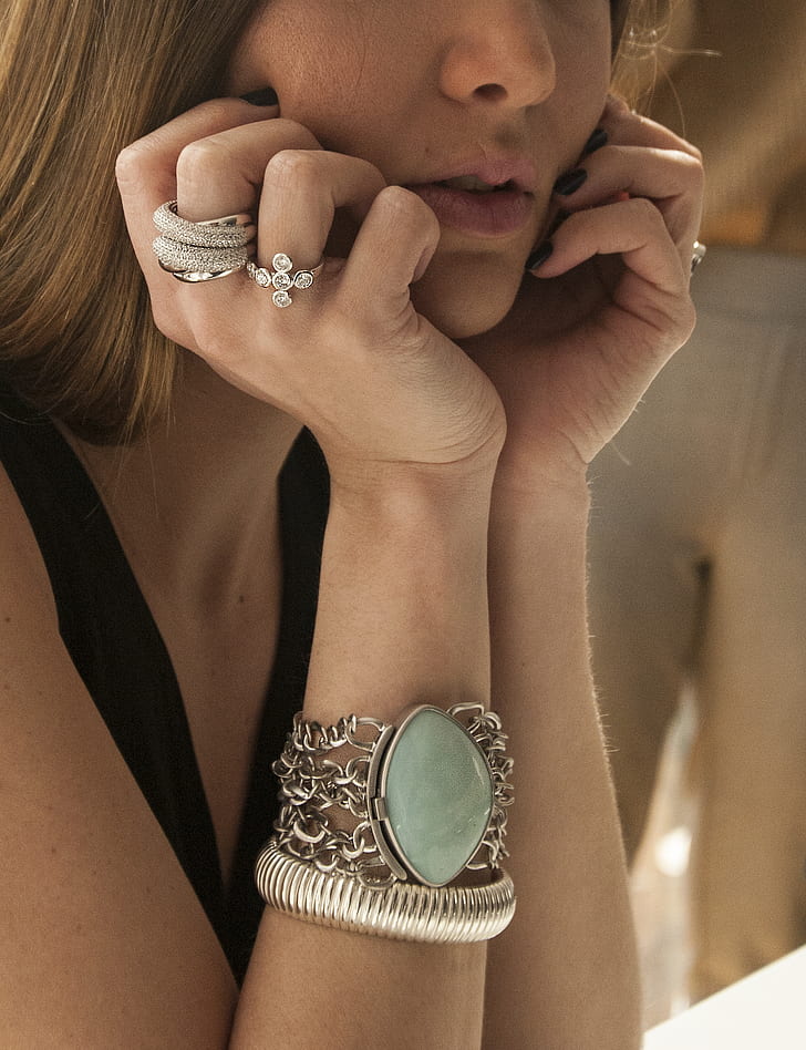 woman wearing silver-colored rings and bracelet taking photo in close-up