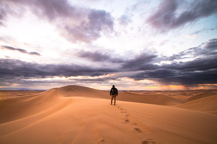 man walking on desert land