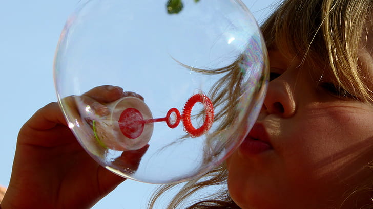 girl making bubble during daytime