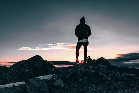 man standing on stone during sunset