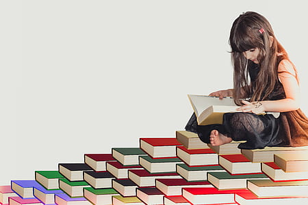 girl reading book on assorted-color book lot