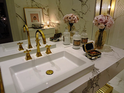gold-colored steel faucet with white ceramic sink