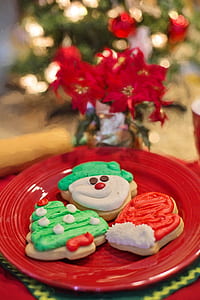 three christmas cookies on round red ceramic plate