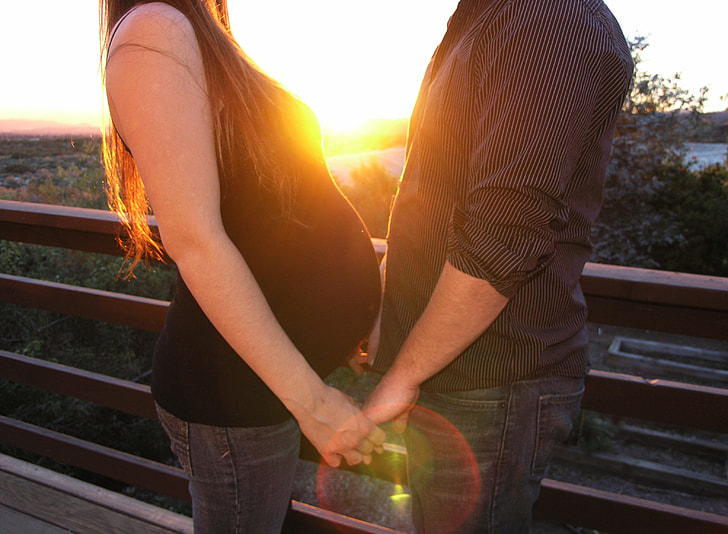 woman and man holding hands during sunset