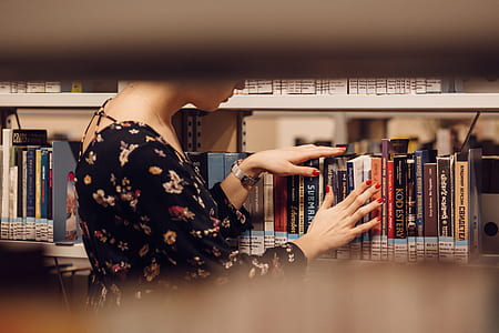 woman in black floral dress on library