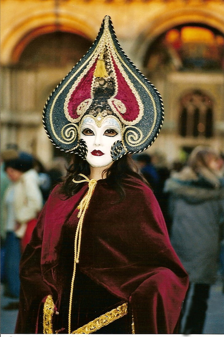 woman weawring red, white, and gray masquerade mask and red robe