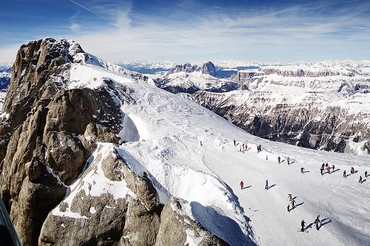 Landscape shot of people skiing on the snow slopes of the Dolomite mountains in Italy