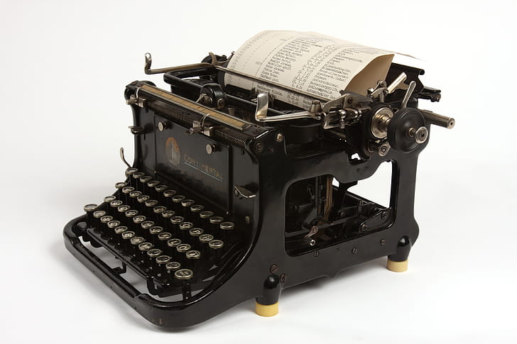 black typewriter with printer paper