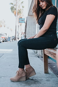 woman in black short-sleeved shirt sitting while looking down