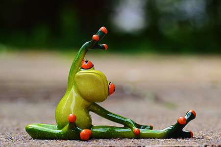 green frog figurine doing yoga