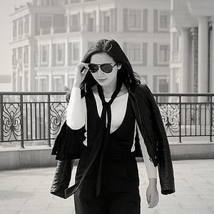 Greyscale Photo of Woman Wearing Sunglasses Long Sleeves Shirt and Skirt during Daytime