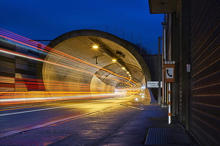 timelapse photography of speeding lights under road tunnel during nighttime