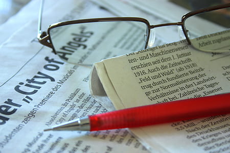 pen on journal beside eyeglasses