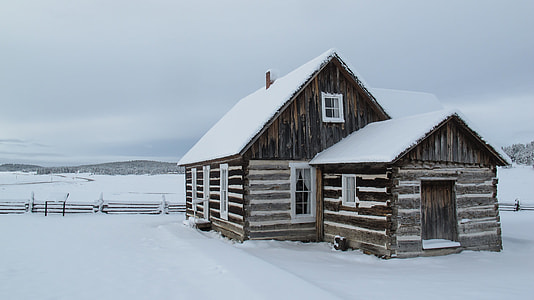 brown and white wooden house with snow at daytime