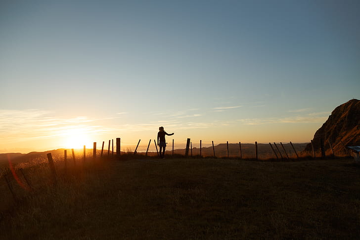 silhouette of man near the fence during golden hour