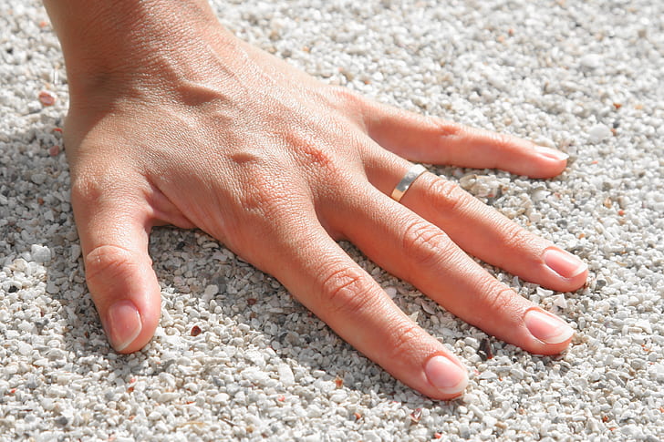 Lef Humand Hand Wearing Silver Ring on the Soil
