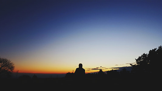 photo of silhouette man facing sky