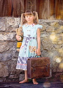 girl carrying suitcase and bear plush toy