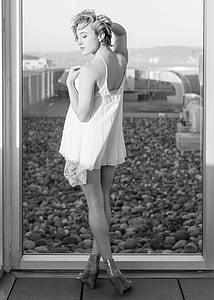 woman in lace camisole top standing near window