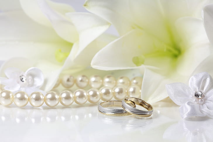 silver-colored rings and white pearl necklace