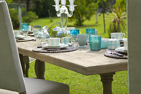 rectangular brown wooden dining table full of white-and-blue dinnerware set