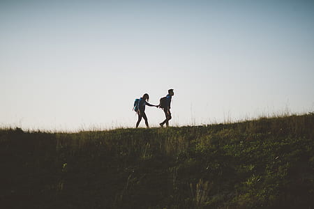 two person walking on top of hill