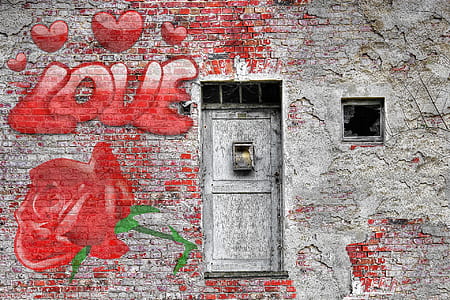 gray concrete wall with red love text graffiti