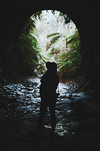 silhouette of person inside a cave photo