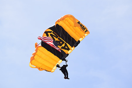 man gliding on yellow and black parachute