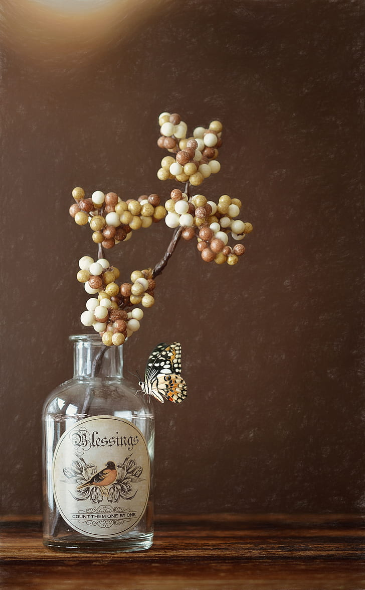 white and brown berries on clear glass bottle