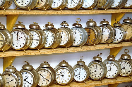 gray alarm clock lot on brown wooden shelf