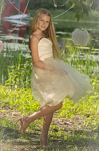 girl in white sweetheart neckline strapless dress on green grass field