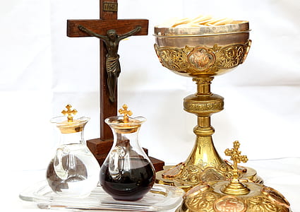 brown wooden crucifix beside a two glass containers and gold goblet