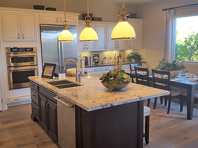 grey kitchen island with three beige pendant lamps turned on