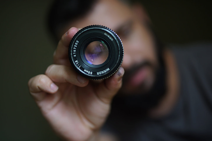 Photographer holding camera lens