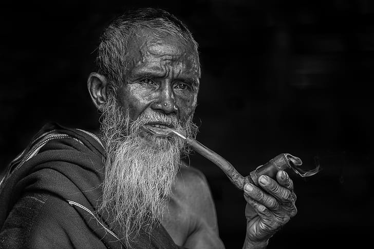 man holding tobacco pipe grayscale photograph