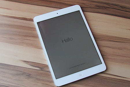 white iPad on brown wooden board
