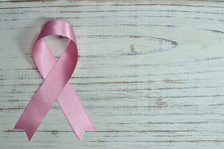 pink ribbon on white wood board surface