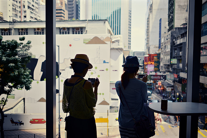 Two women looking through a window in Hong Kong, China