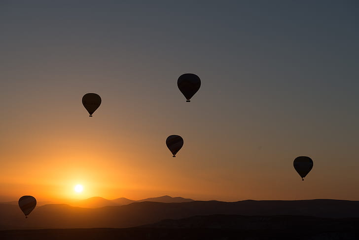 silhouette of five hot air balloons during sunset