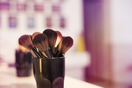 makeup brush on vase on table top