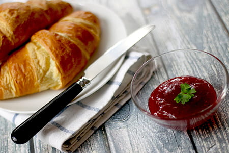 baked croissants on round white ceramic plate with red dipping sauce