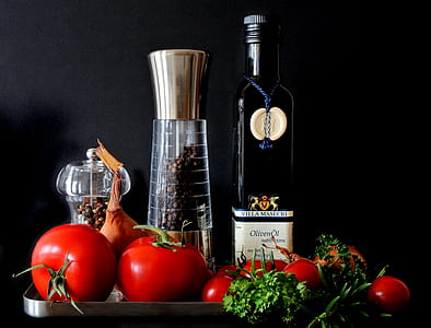 Tomatoes Beside Shakers and Olive Oil Bottle